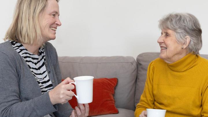 Two people talking over a hot drink