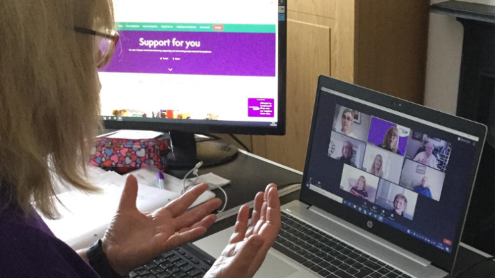 Woman in front of laptop on a Zoom call with others