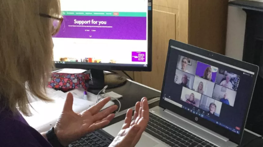 Woman in front of laptop on a Zoom call with others
