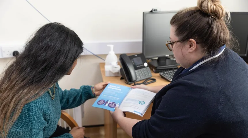 Nurse discussing content of information book with patient