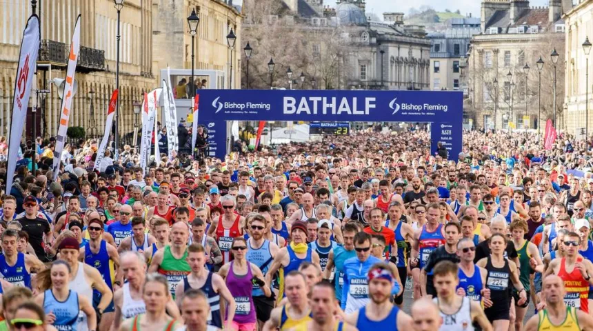 large amount of runners, passing halfway mark banner
