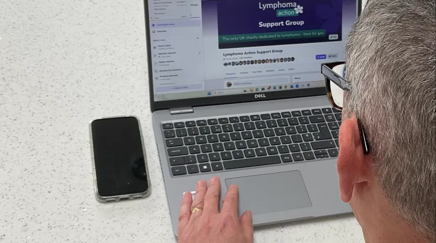 A person sitting at a desk with a laptop open in front of them.