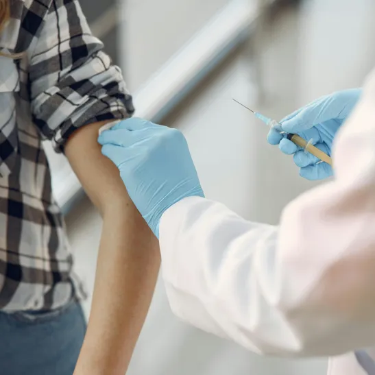 Woman getting an injection into her left upper arm.