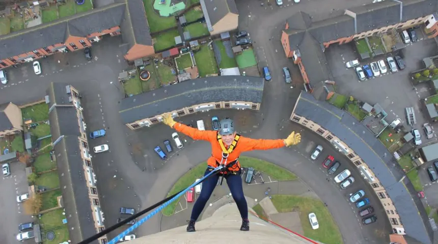 Abseiler looks up and smailes half way down the lift tower