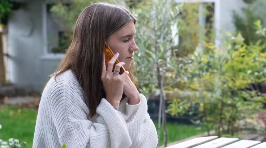 Woman sat outside on the phone