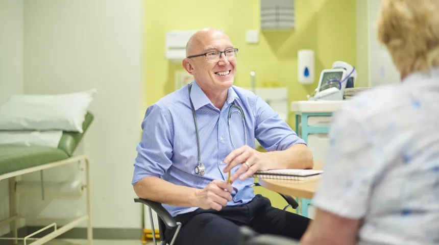 GP smiling and facing a patient