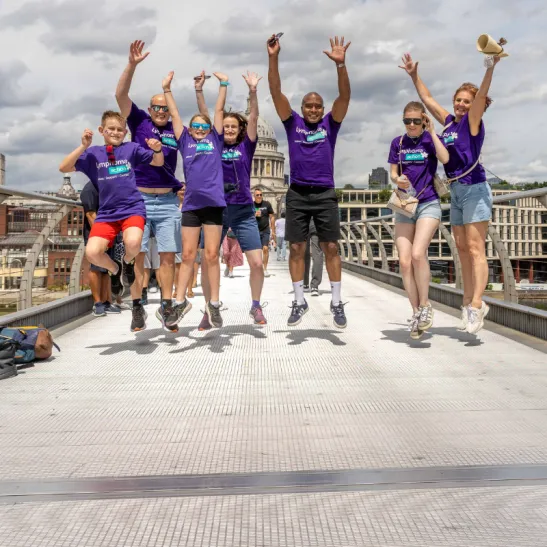 Lymphoma Action supporters jumping against a backdrop of a London bridge. 