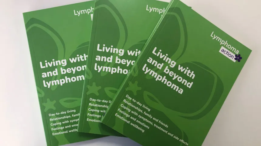 3 copies of our living with and beyond lymphoma book that has a green cover and periwinkle