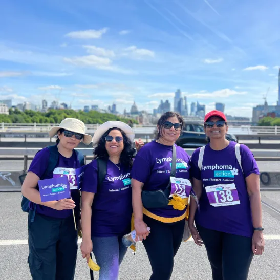 Four Lymphoma Action supporters smiling to camera against a backdrop of London scenery. They are taking part in Lymphoma Action's Bridges of London walking event.
